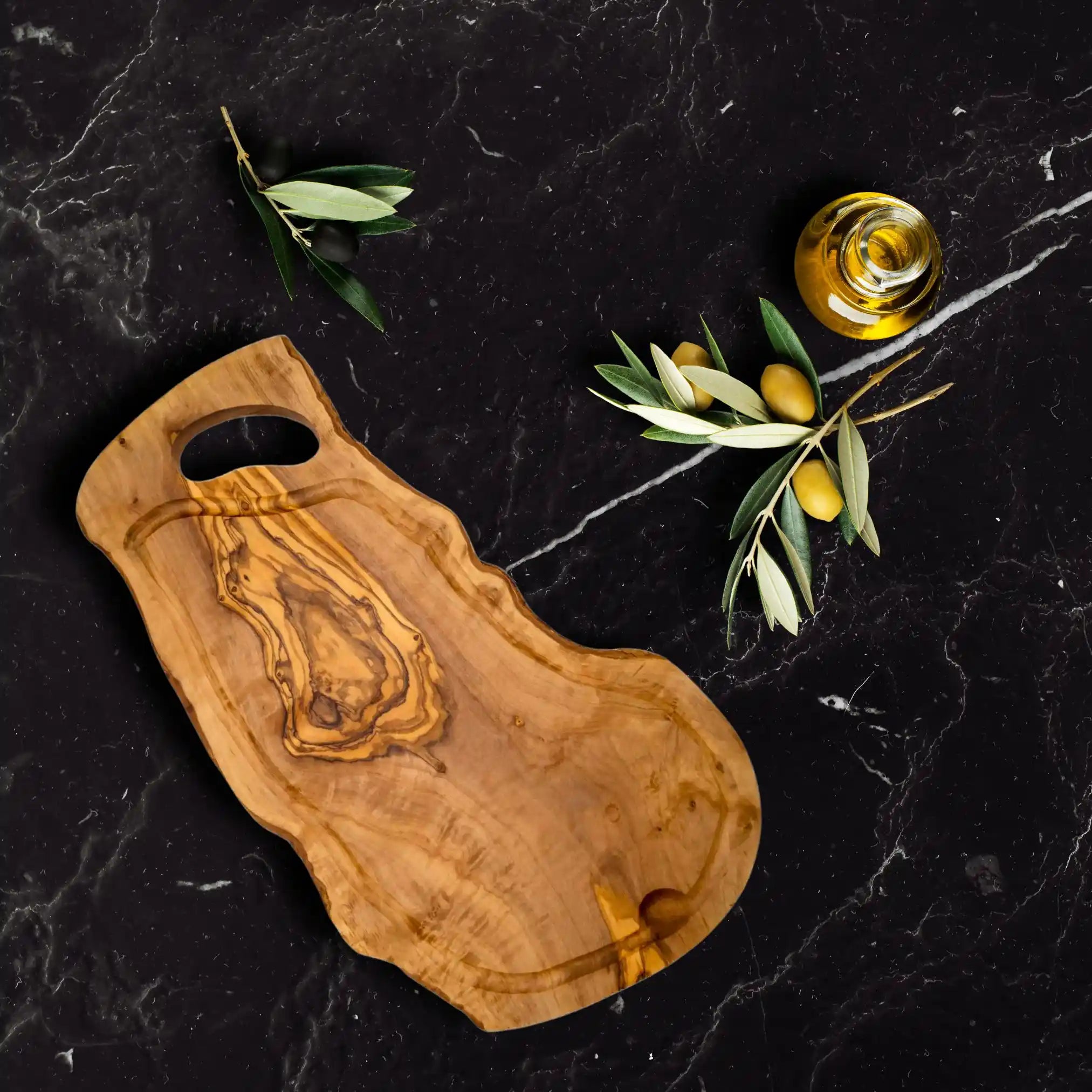 An olive cutting board with handcrafted juice groove showcased on a rustic dinning table.