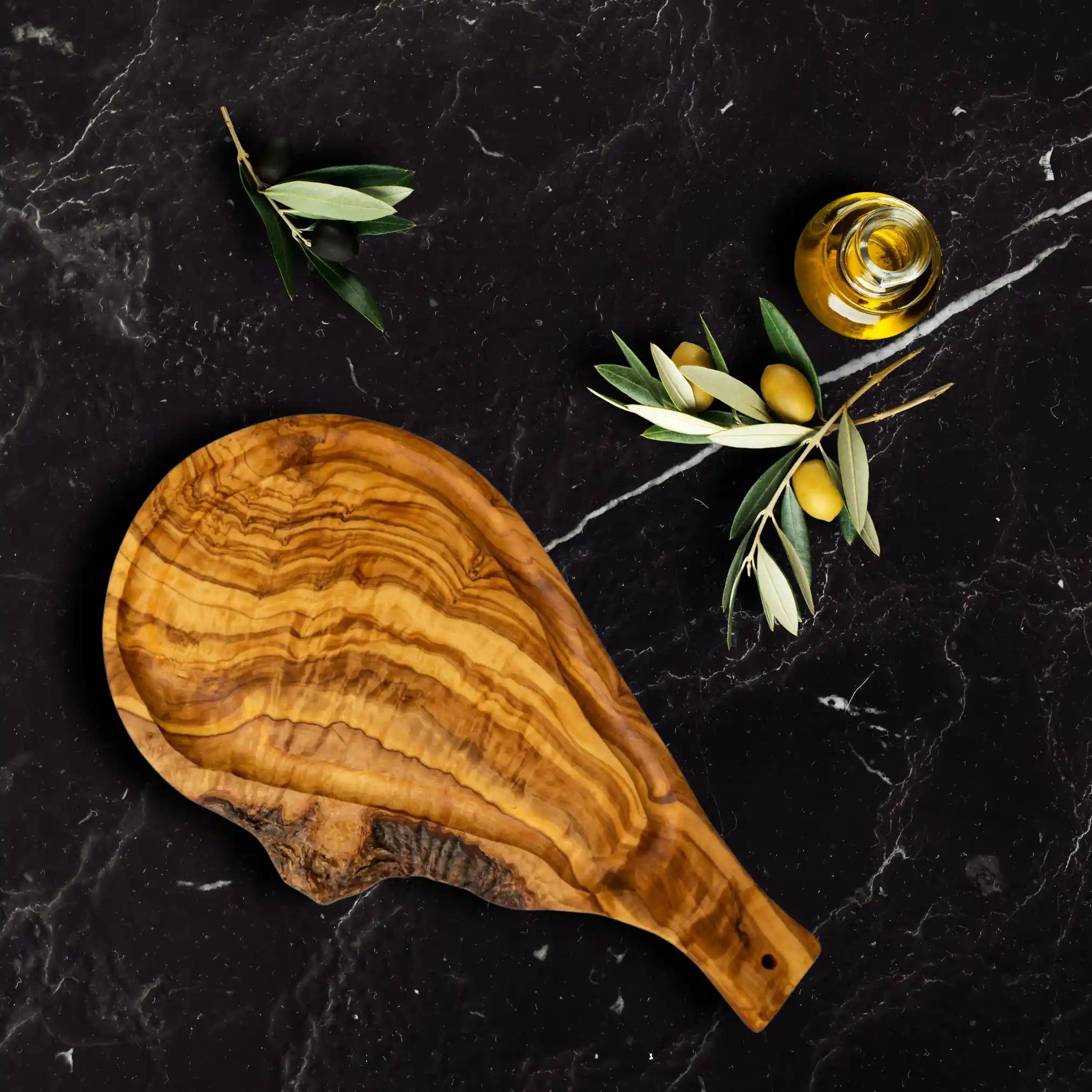 An olive steak board with a carved juice groove placed on a luxury dinning table.