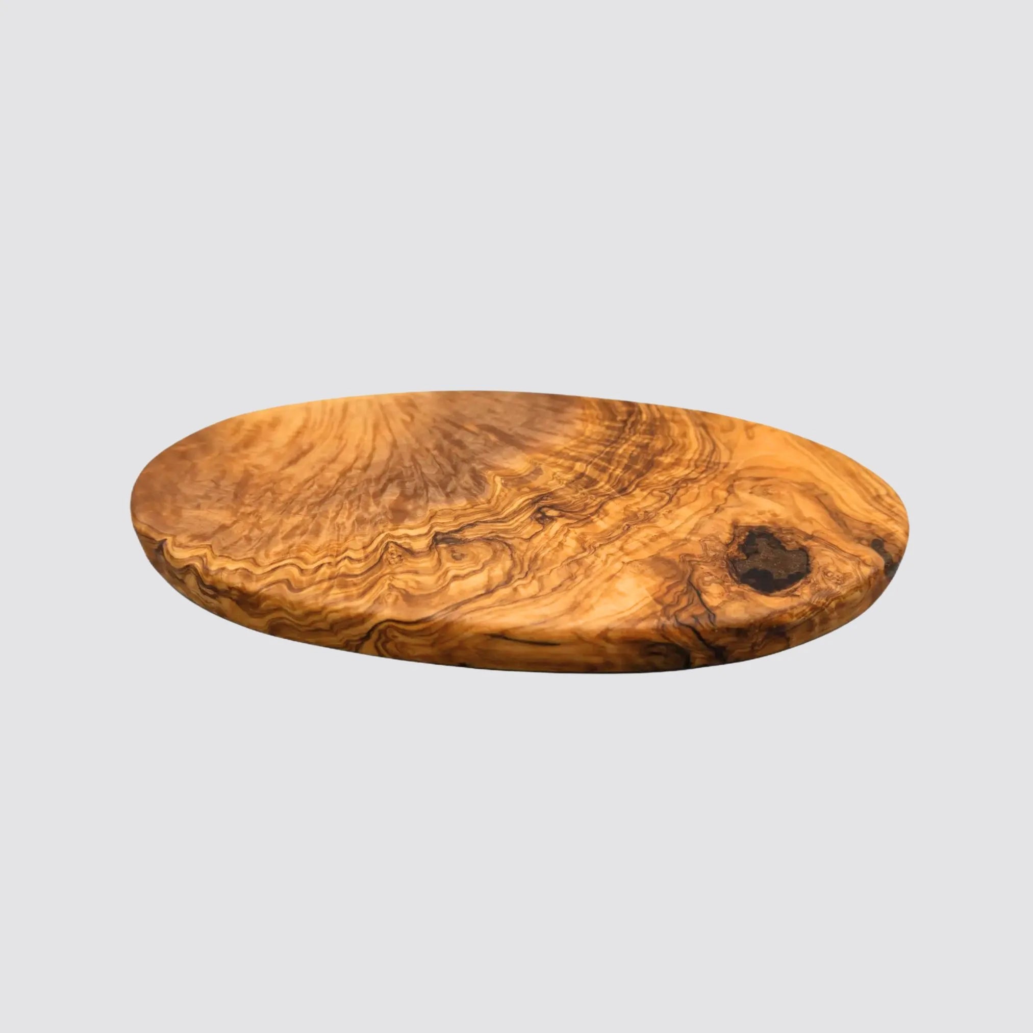 Artisan oval olive wood serving board featuring a smooth finish on a plain background.