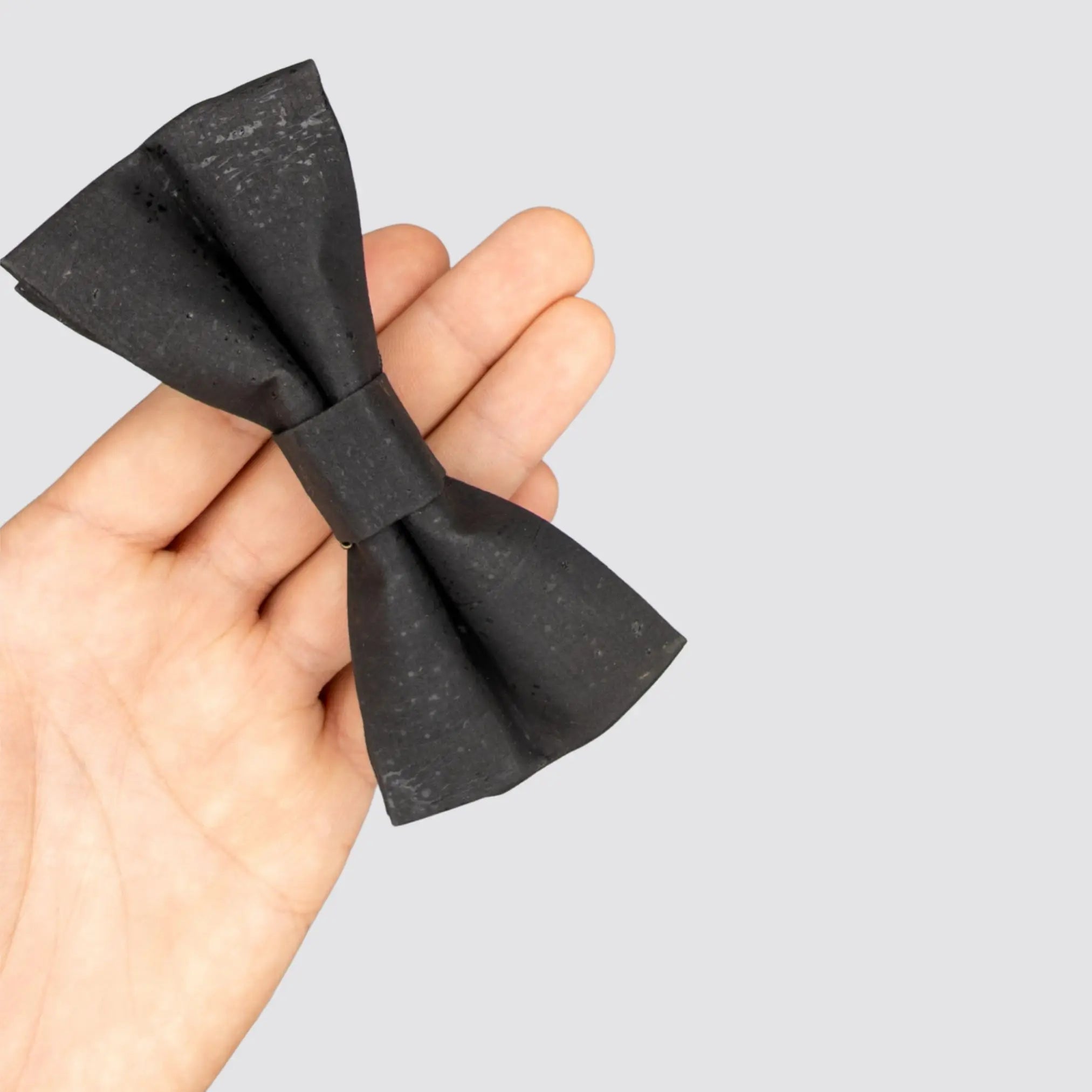 Overhead view of the Black Cork Bow Tie held in the palm of a hand.