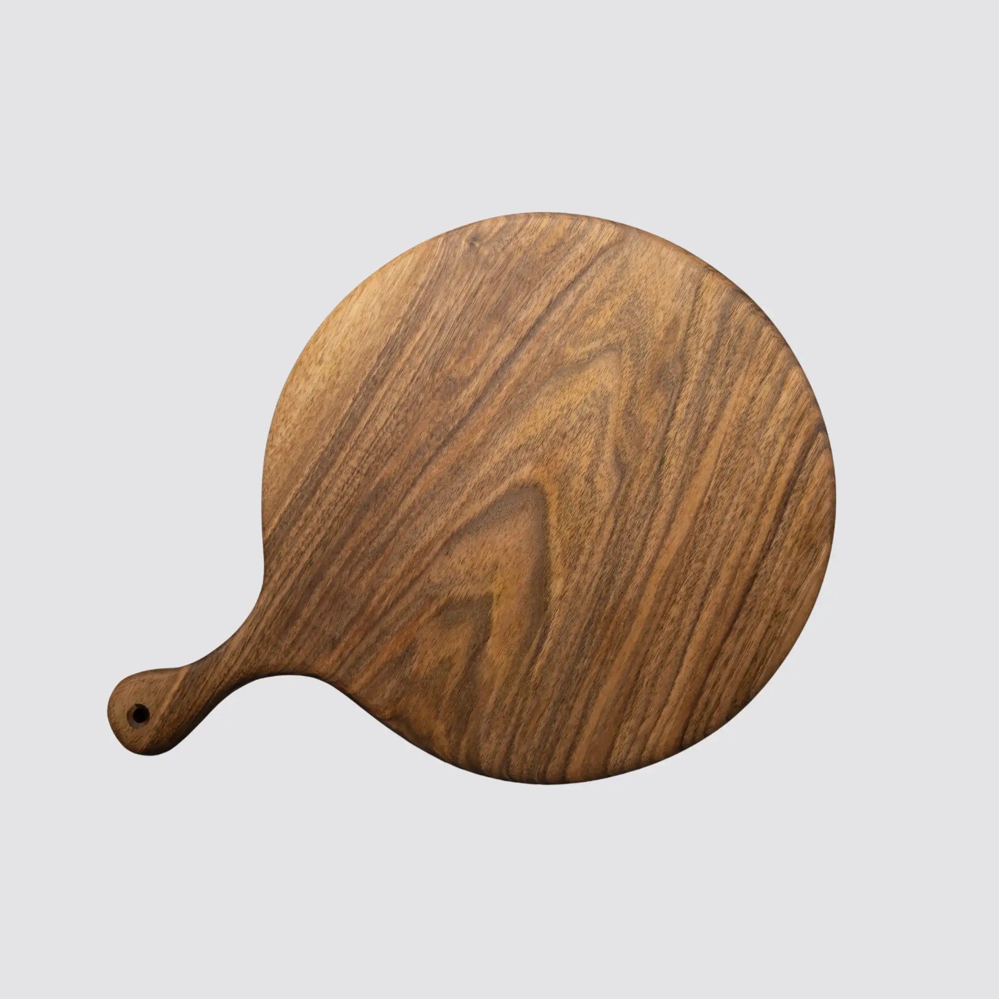 Elegant walnut serving board with handle displayed on a light background, highlighting its natural beauty.
