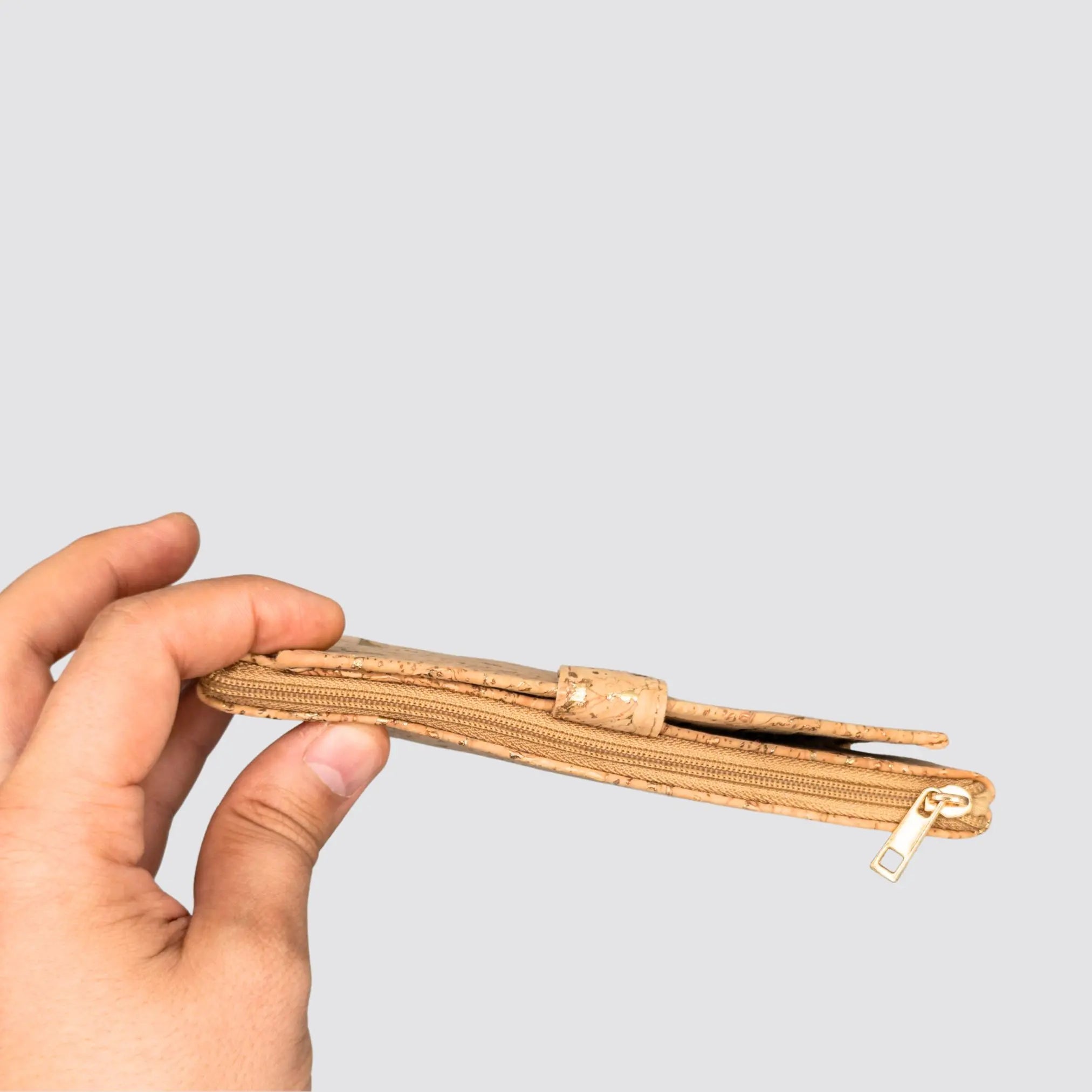 Gold Cork Slim Wallet held in hand, showcasing its compact size and sleek design, on a plain background.