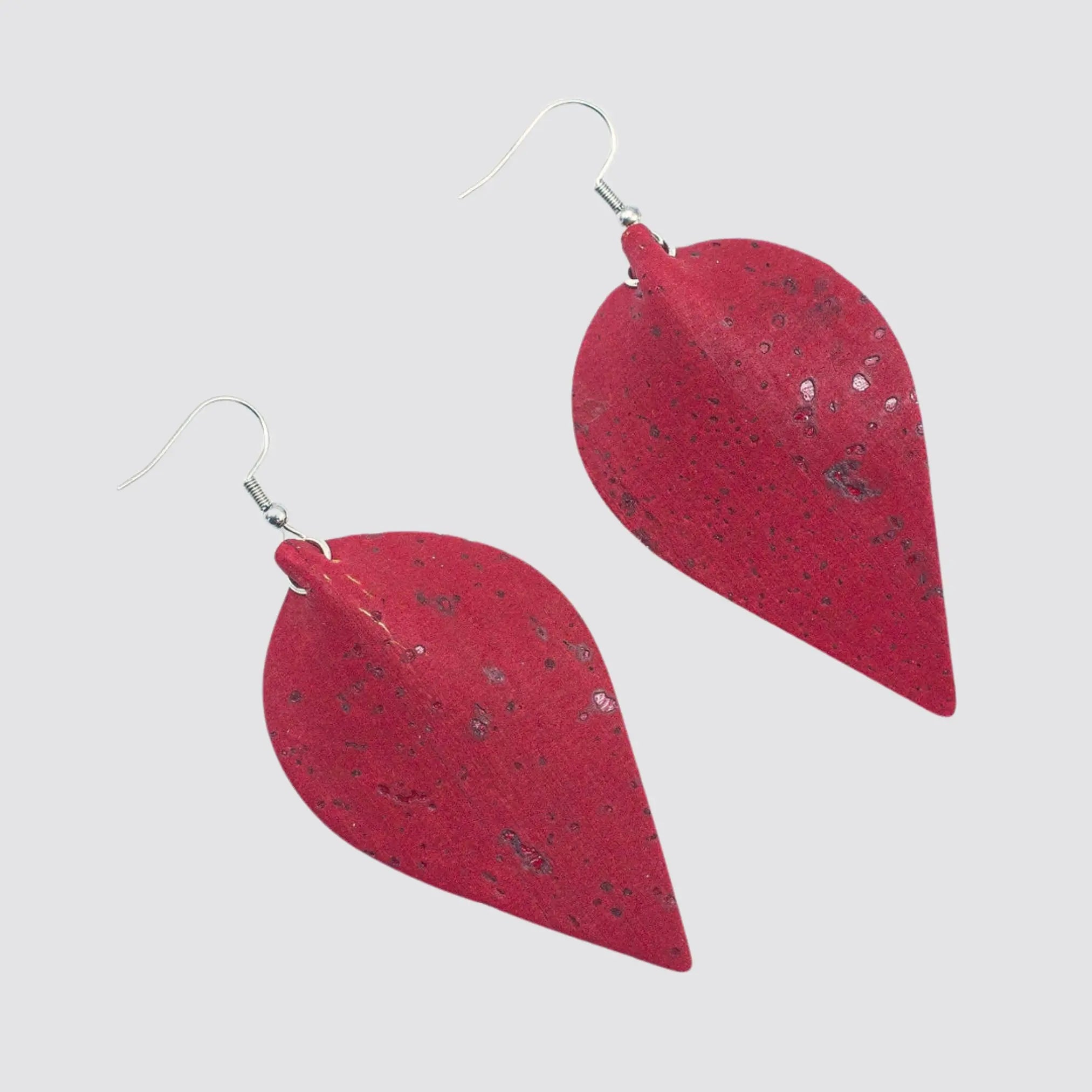 Handcrafted cork drop earrings featuring a contemporary design and zamak metal accents.