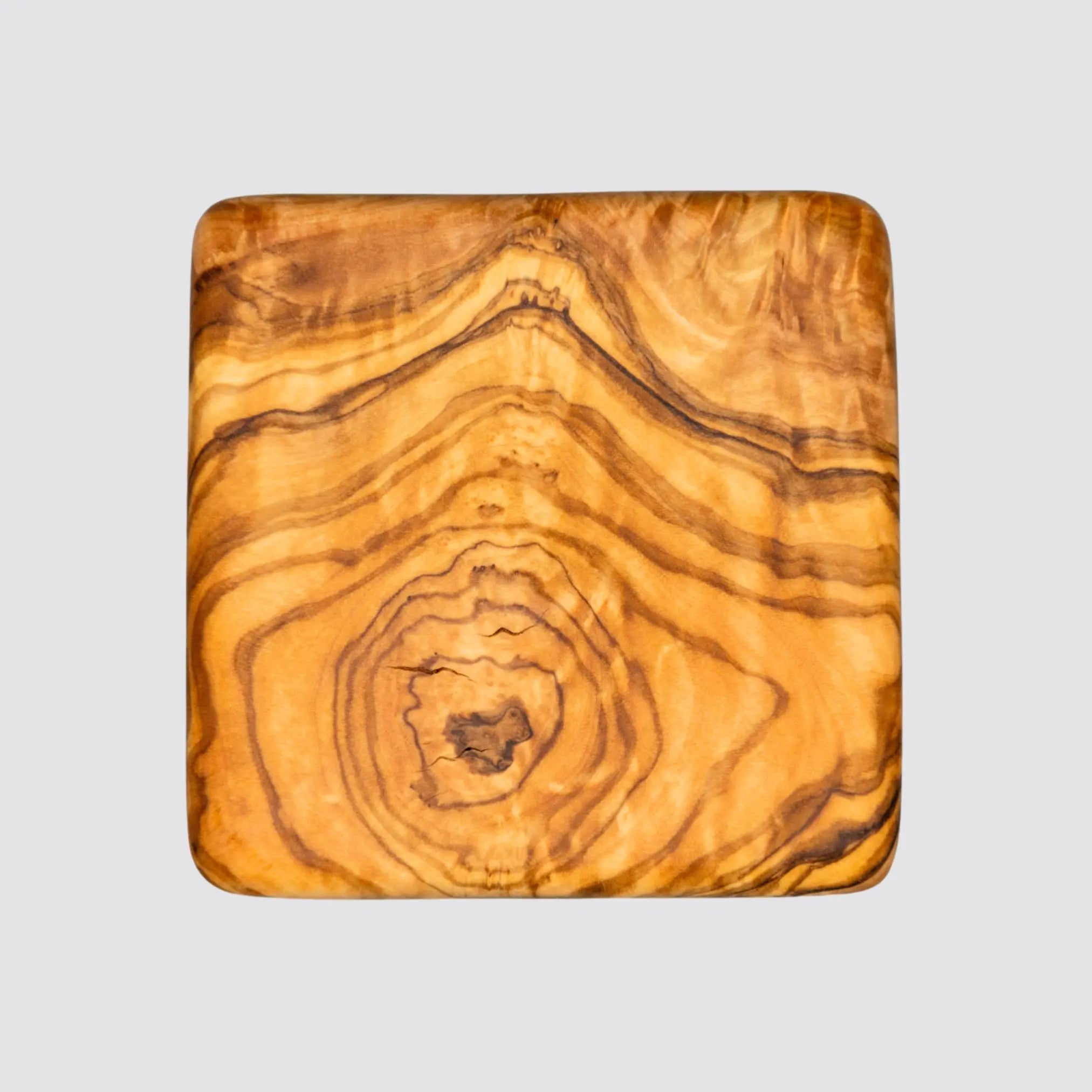 Handcrafted olive wood coaster for protecting surfaces from heat and moisture.