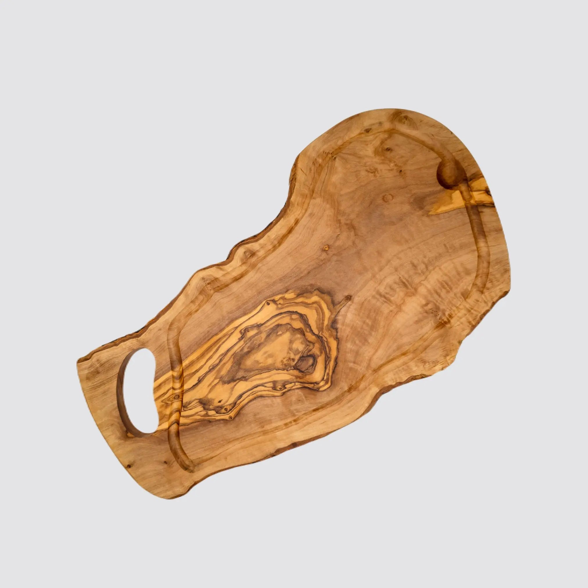 Handcrafted olive wood cutting board featuring a carved juice groove.