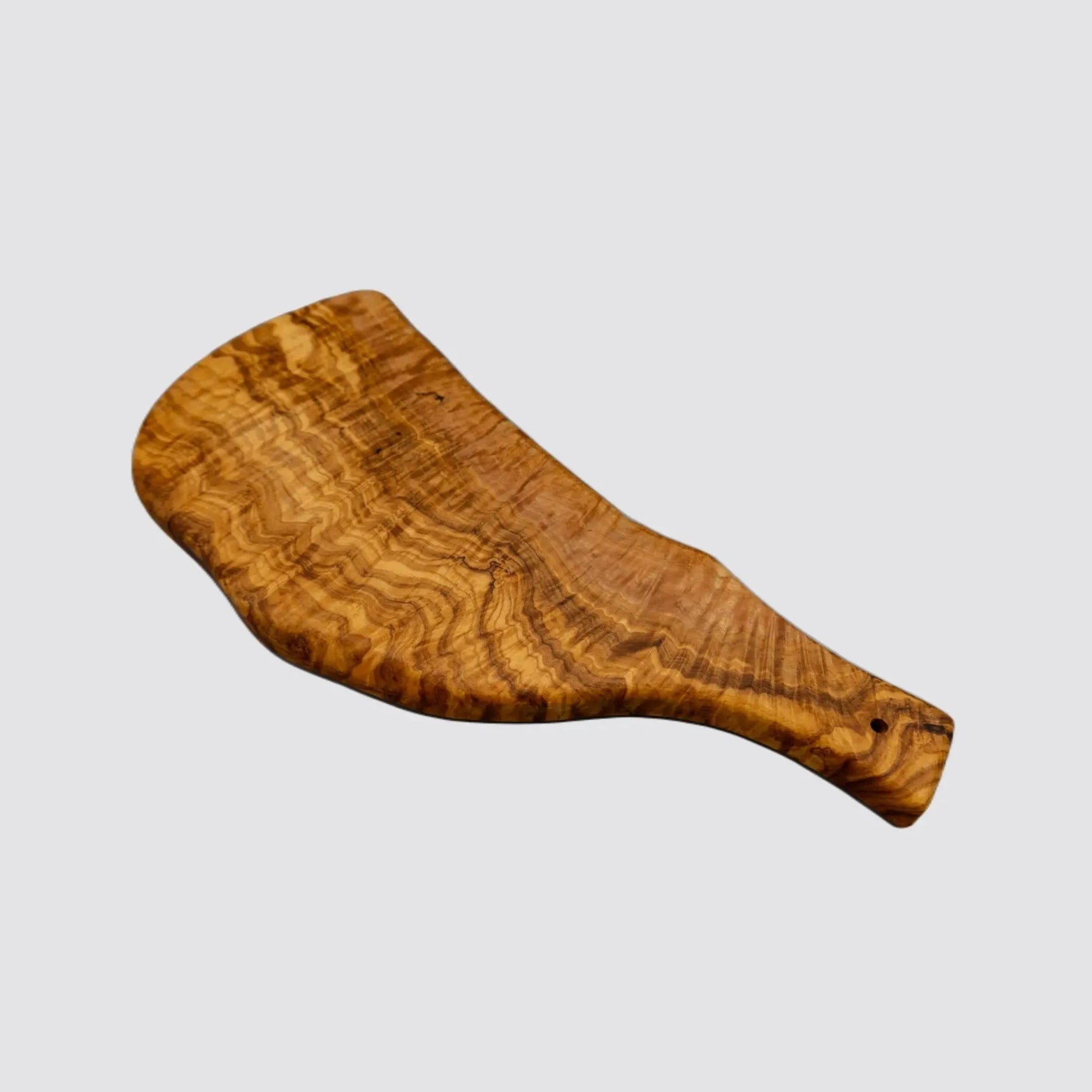 Close-up of the beautiful grain patterns of a handcrafted olive wood serving board on a plain white background.
