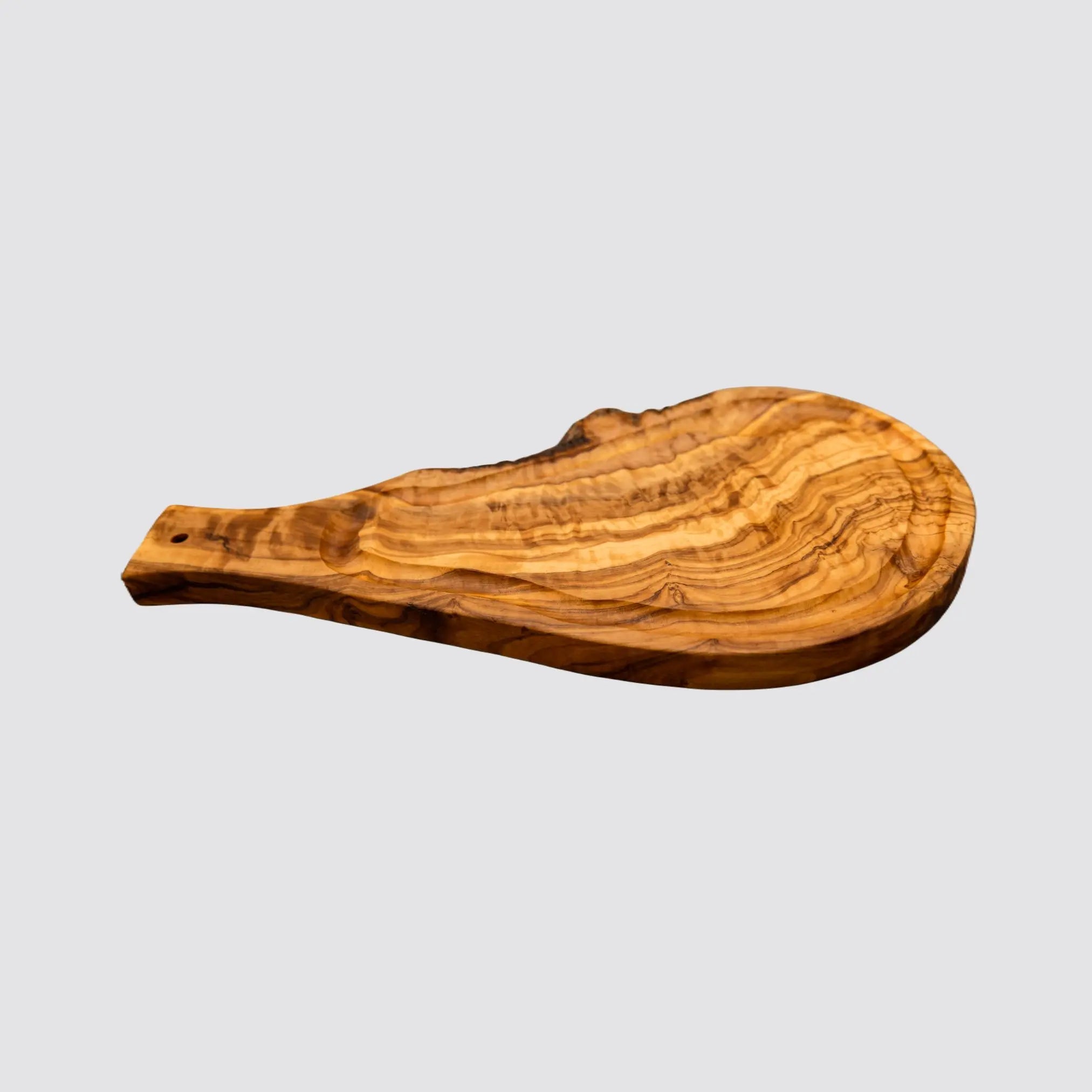 Handcrafted olive wood steak serving board showcasing unique grain patterns.