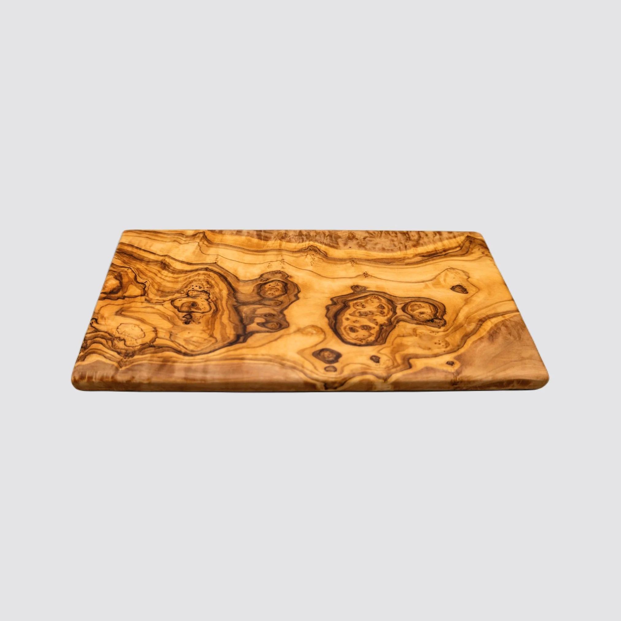 Front view of a handcrafted rectangle olive wood serving board on a plain background.