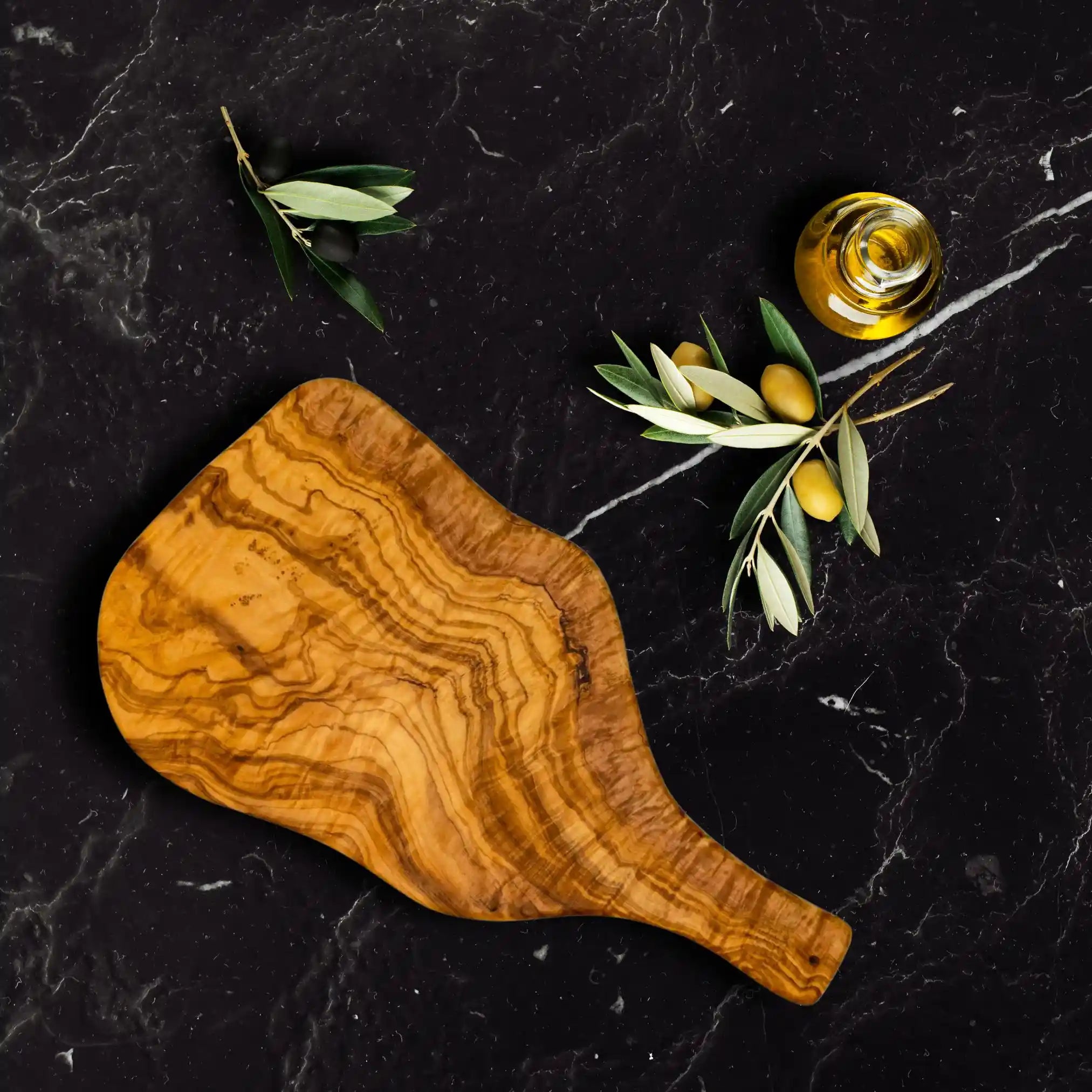 The olive serving boards is styled luxuriously on a rustic dinning table.
