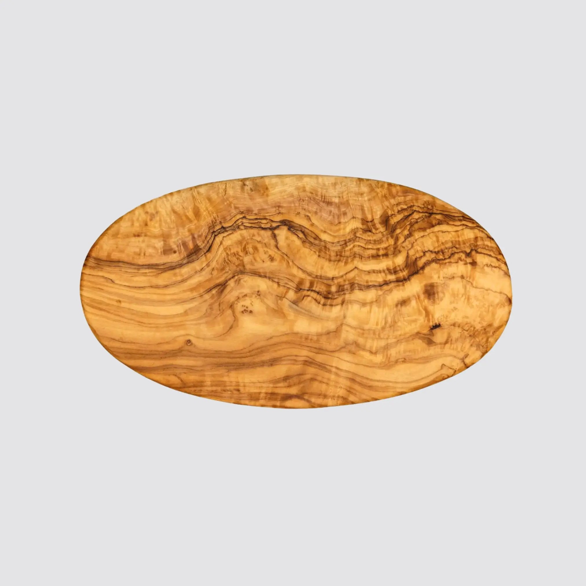 Oval olive wood board highlighting unique grain details on a plain background.
