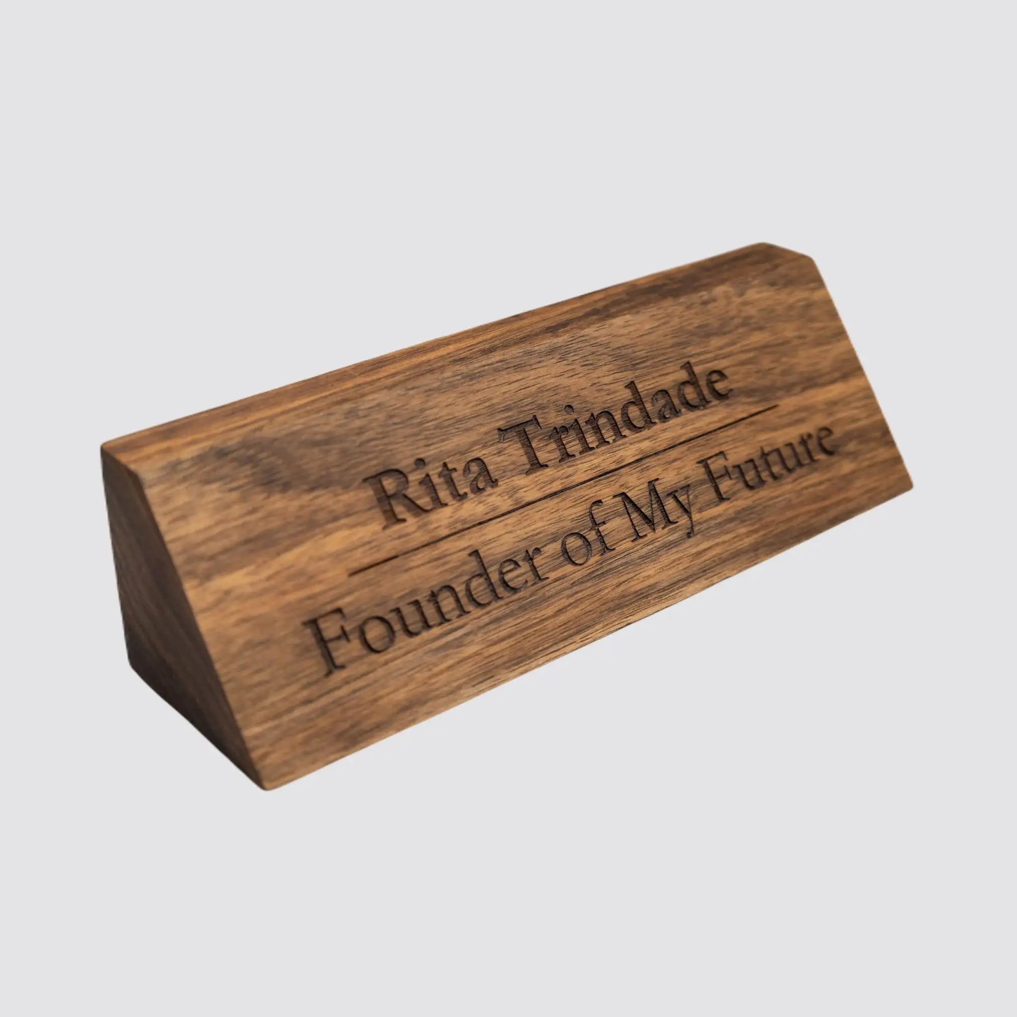 Side view of a personalized walnut desk name plate, highlighting its sleek edges and natural wood grain on a plain white background.