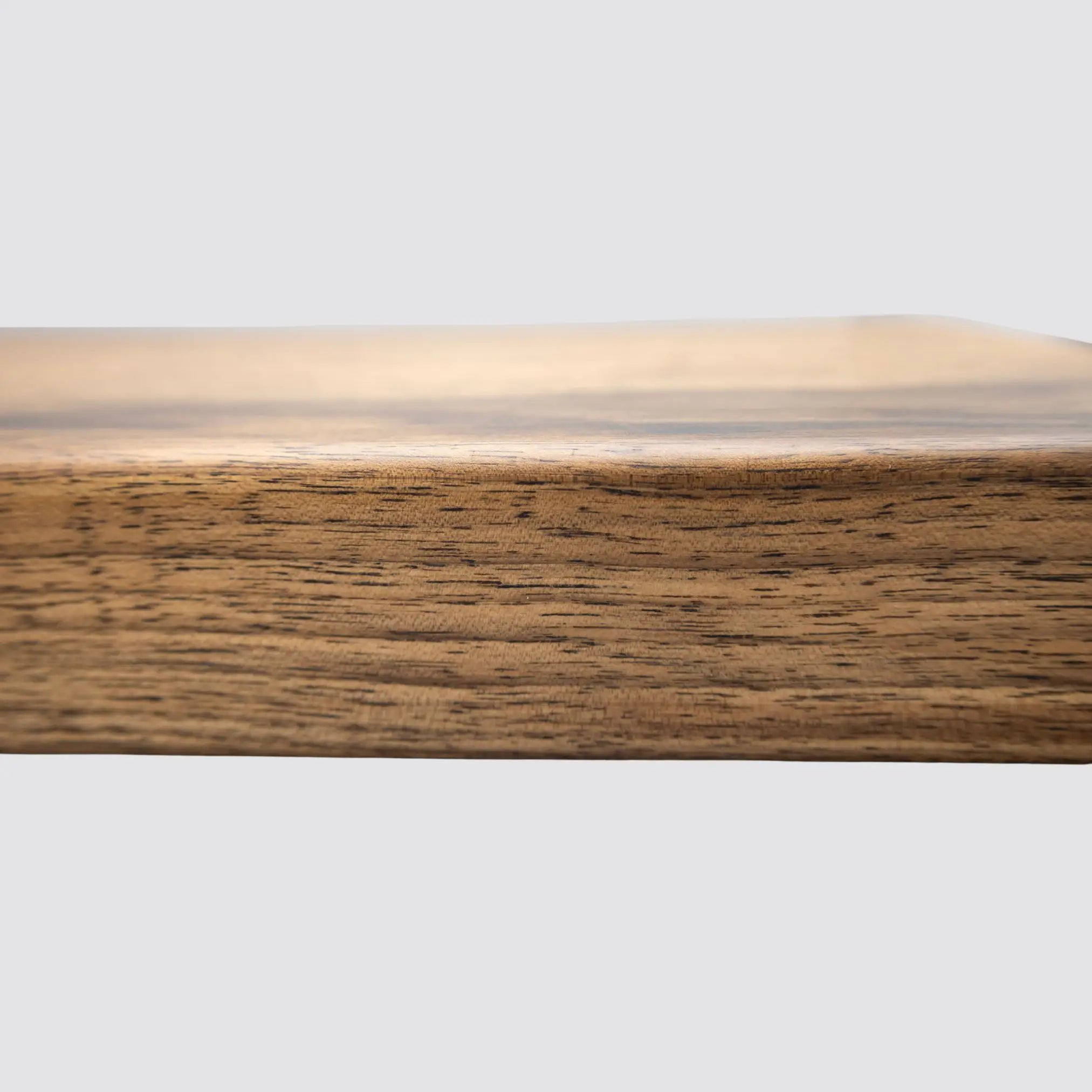 Close-up of a thick premium walnut cutting board, focusing on natural wood grain patterns.