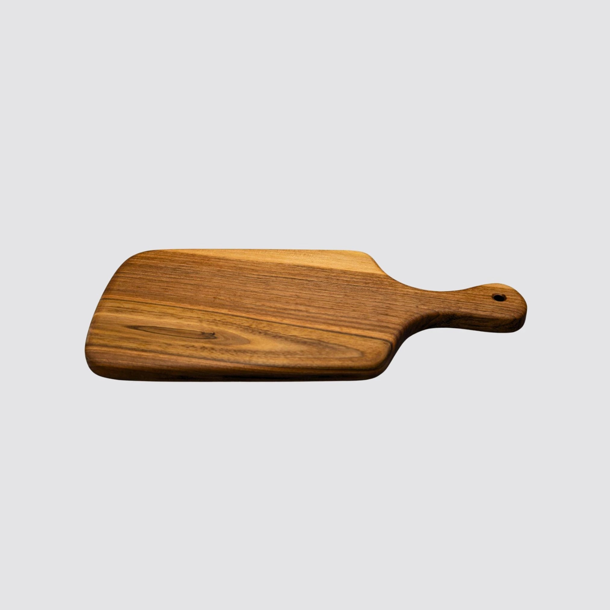 The walnut cheese board with handle displaying its premium handcrafted style, viewed from the side.