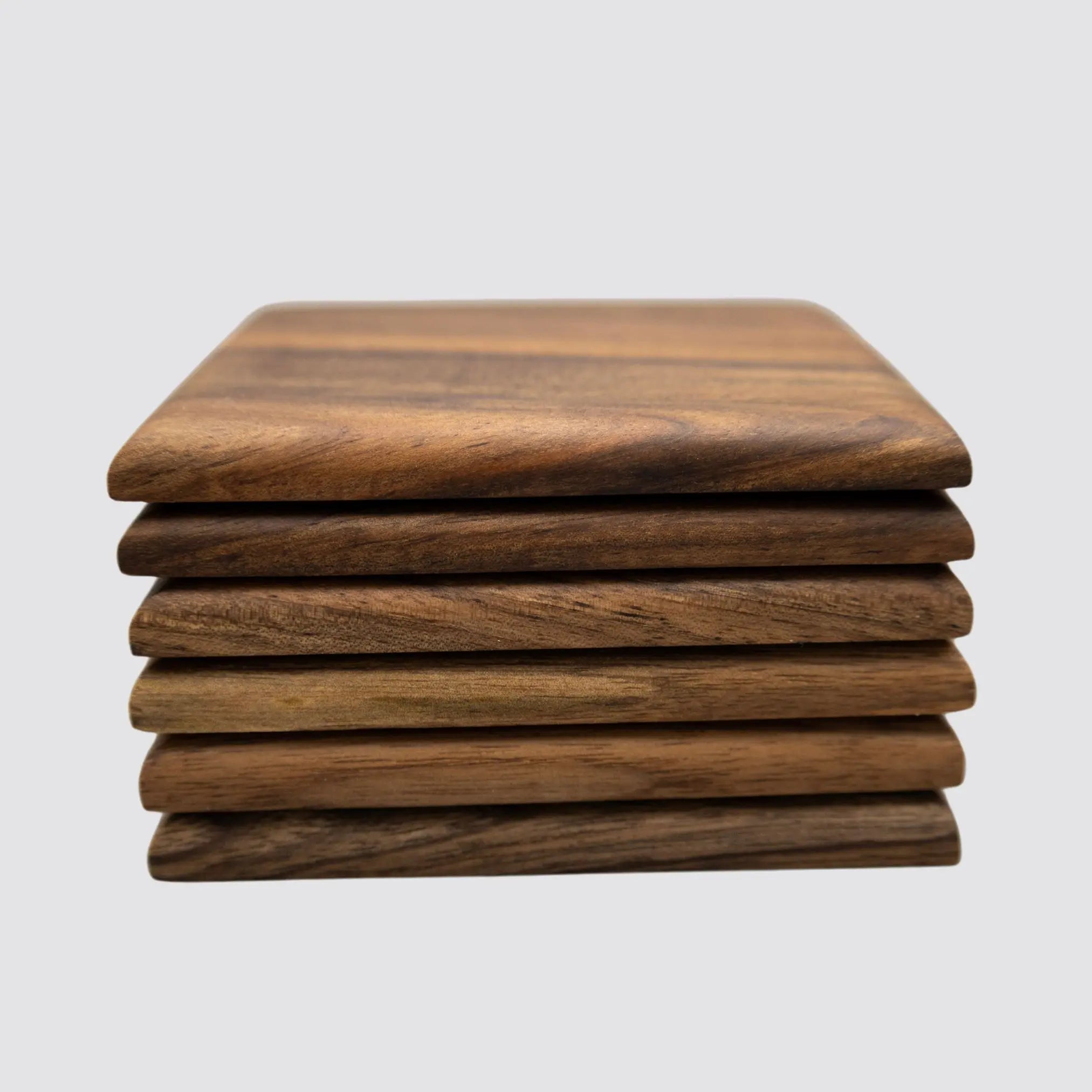 Premium walnut coasters stacked on a light background, showcasing their thickness and craftsmanship.
