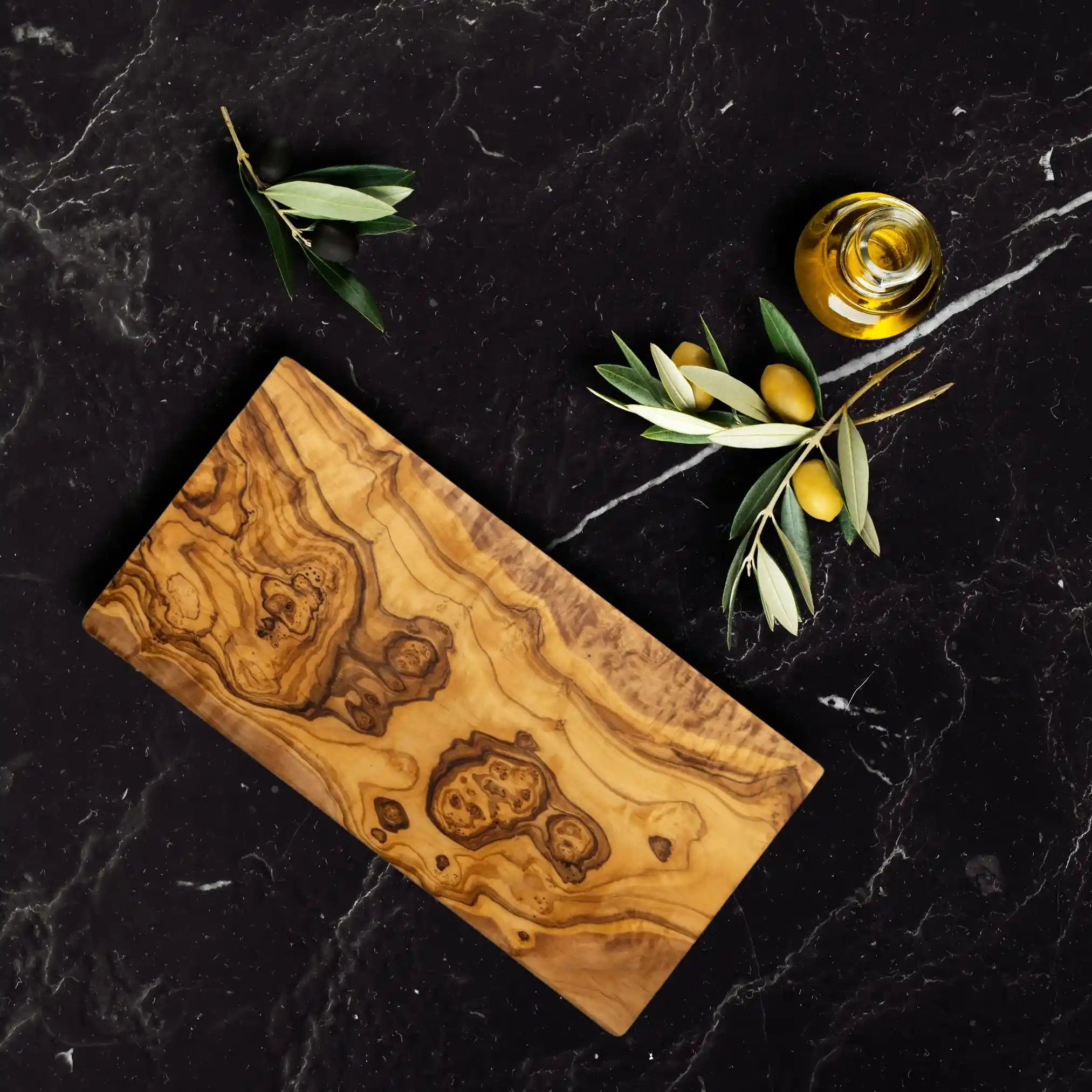 The rectangle olive serving board with its intricate rustic design, is placed on a luxury dinning table.