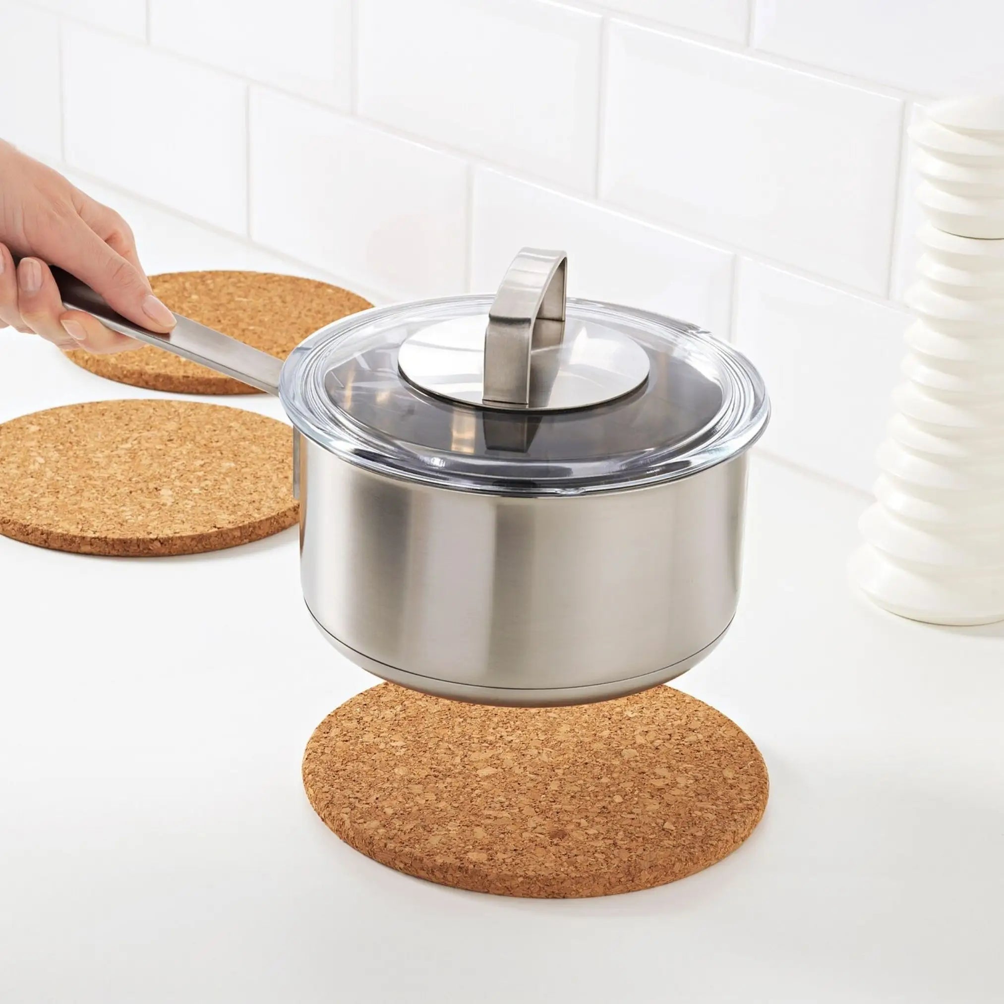 The sustainable cork placemat is placed on top of a kitchen counter with a hot pot on top of it.