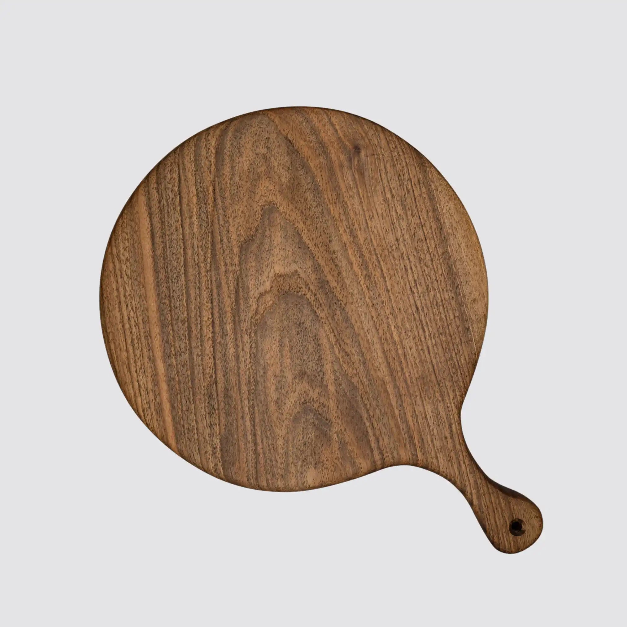 Front view of a round walnut charcuterie board with handle, showcasing its smooth finish.
