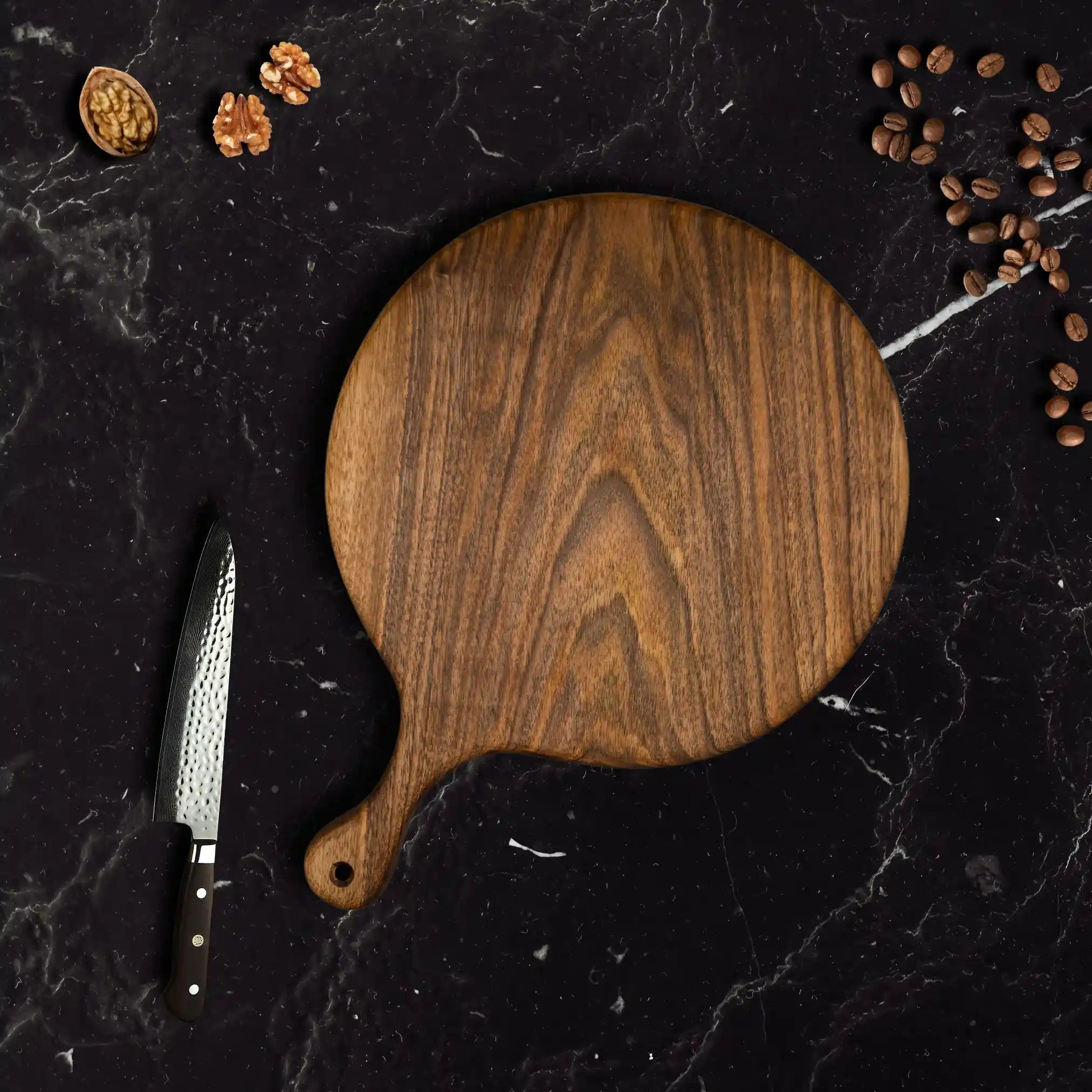 The round walnut serving board is displayed on a luxurious dining table.