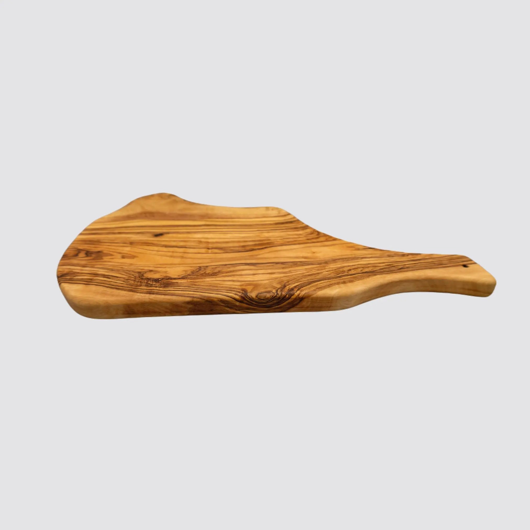 Side view of a rustic olive wood charcuterie board highlighting its natural edges and thickness on a plain white background.