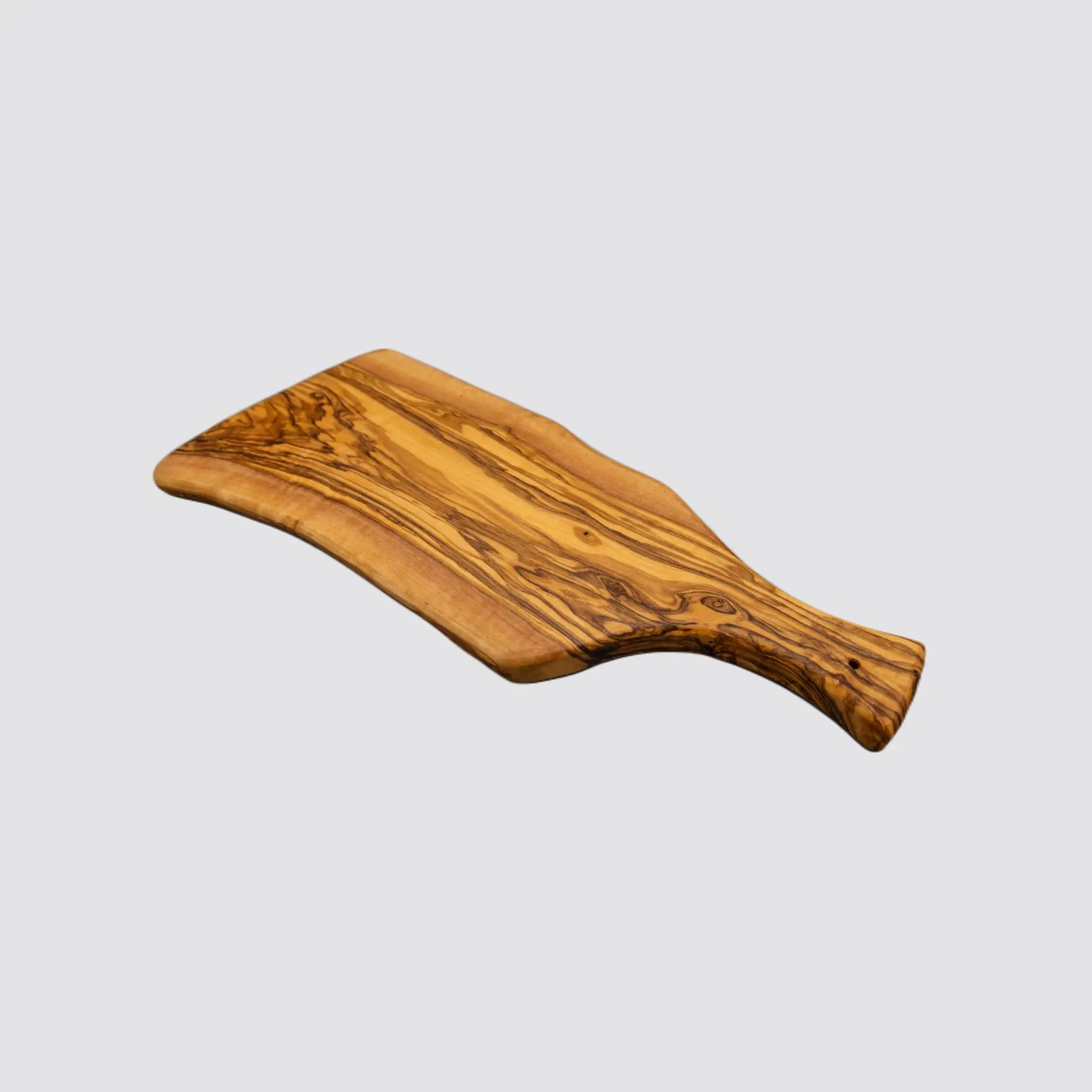 Angled view of a rustic olive wood cheese board, emphasizing its organic edges and polished surface on a plain white background.