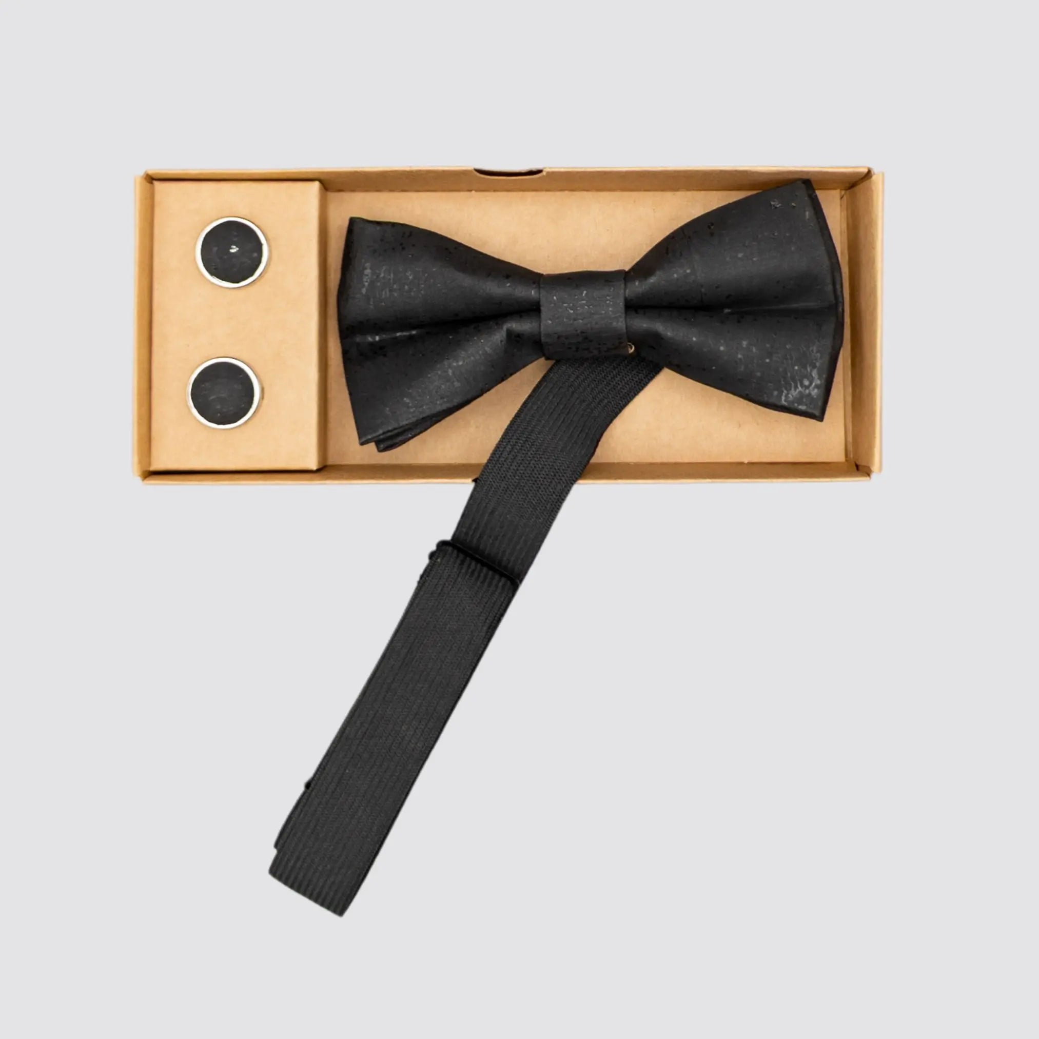 Sleek black cork bow tie with polished copper cufflinks for formal events.