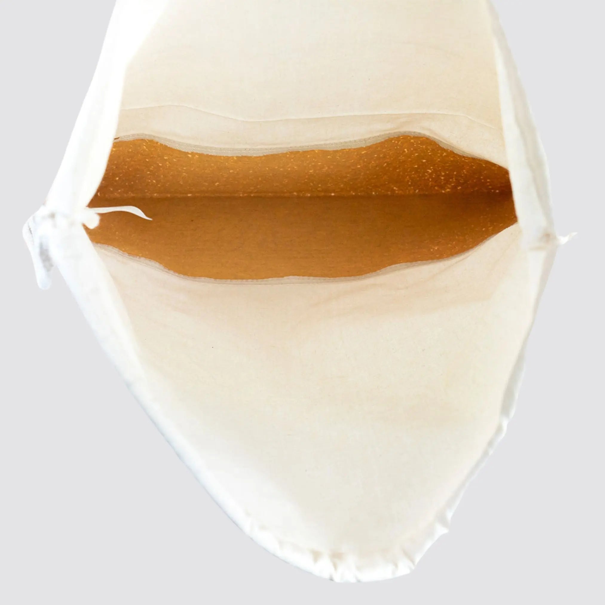 Spacious natural cotton drawstring bag with a cork bottom for durability.