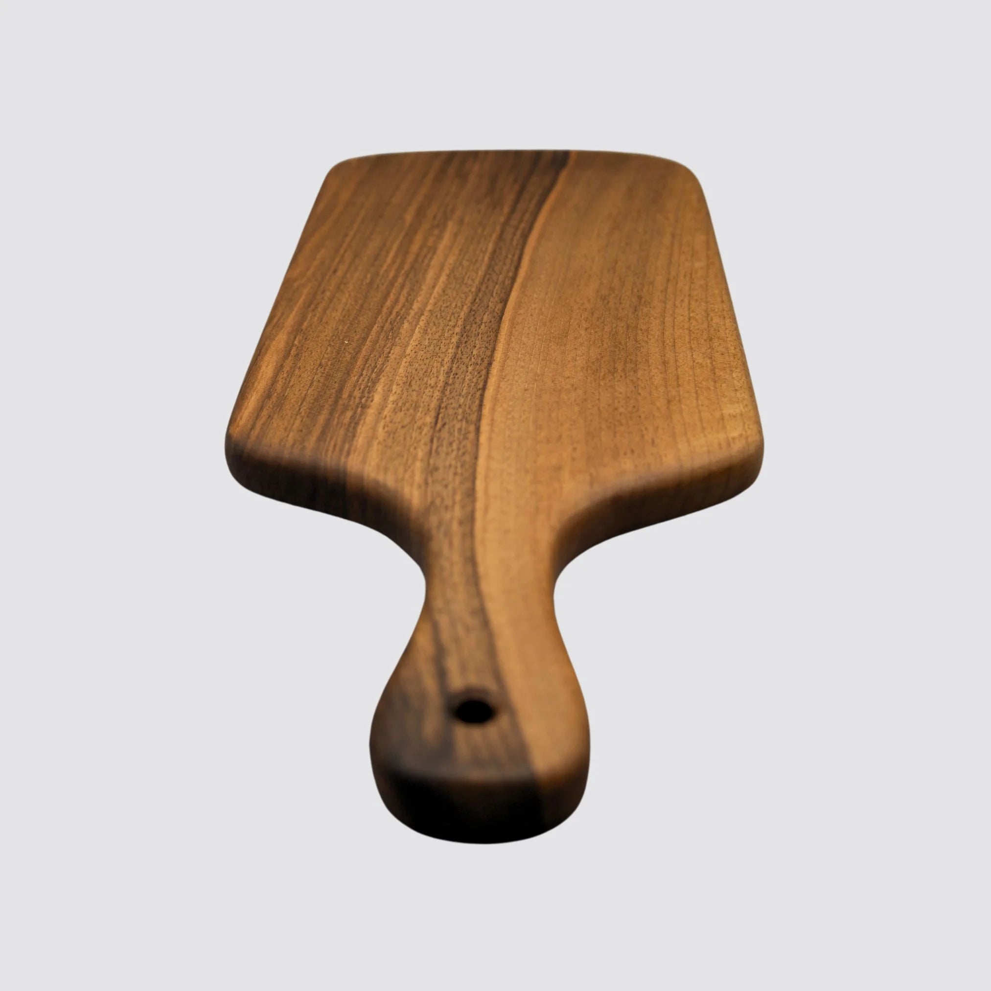 The walnut cheese board highlights its beautiful handcrafted handle.