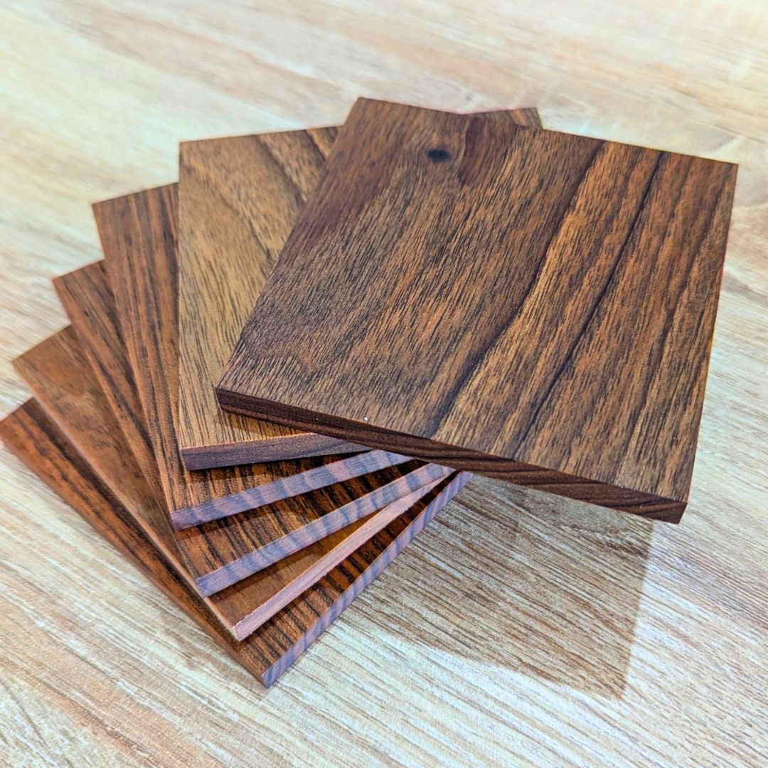 The drink coaster set is made of walnut wood and is placed on a luxury dinning table.