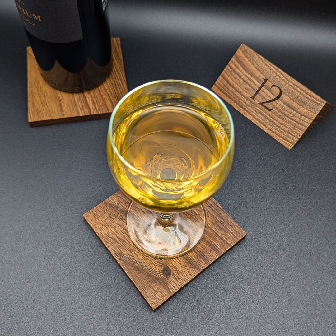 The drink coaster set is made of premium walnut wood and is displayed elegantly on a table.