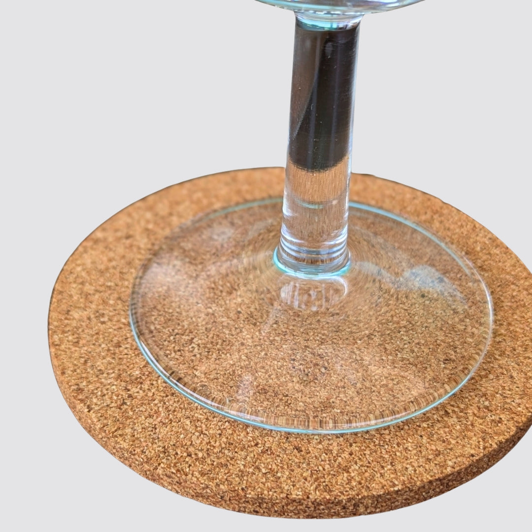 Cork coaster with a glass of water on a white background
