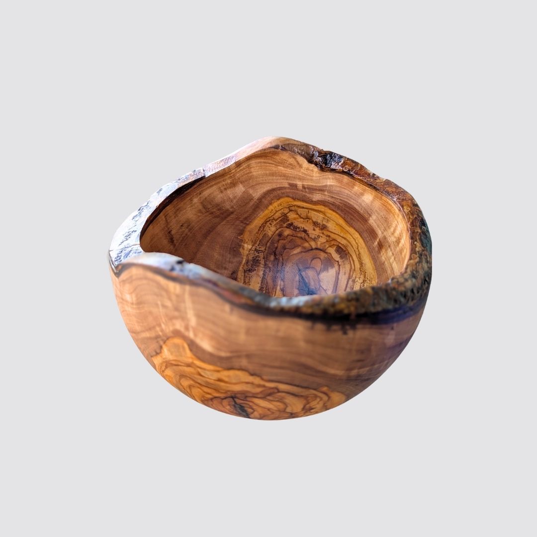 Wooden olive bowl with a natural rustic edge on a light gray background